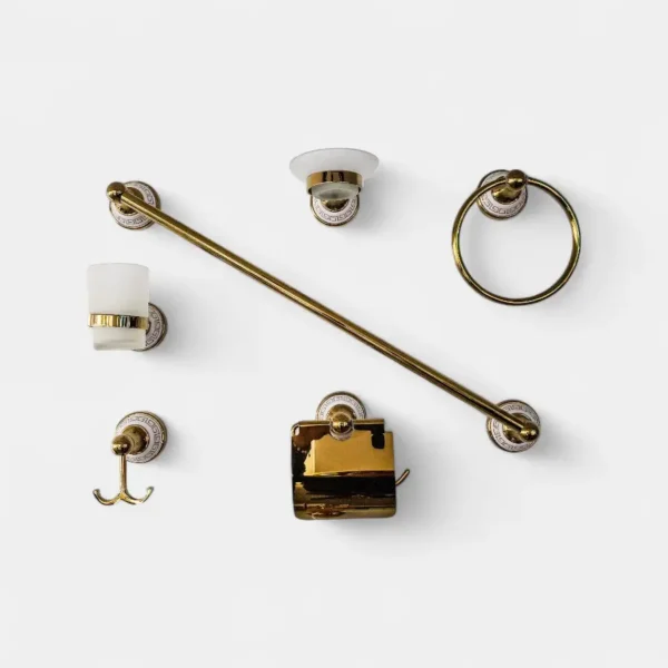 Set de accesorios de baño, acabado dorado con base de cerámica, que incluye barra para toalla, jabonera y varios artículos para el baño.