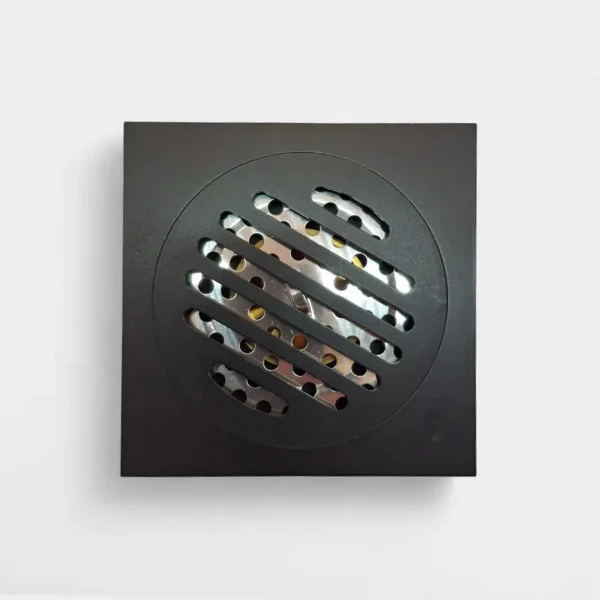 Rejilla anti olor de 10x10 cm negra mate con ranuras diagonales – Estilo contemporáneo y eficiencia en drenaje en INNOVA HOGAR